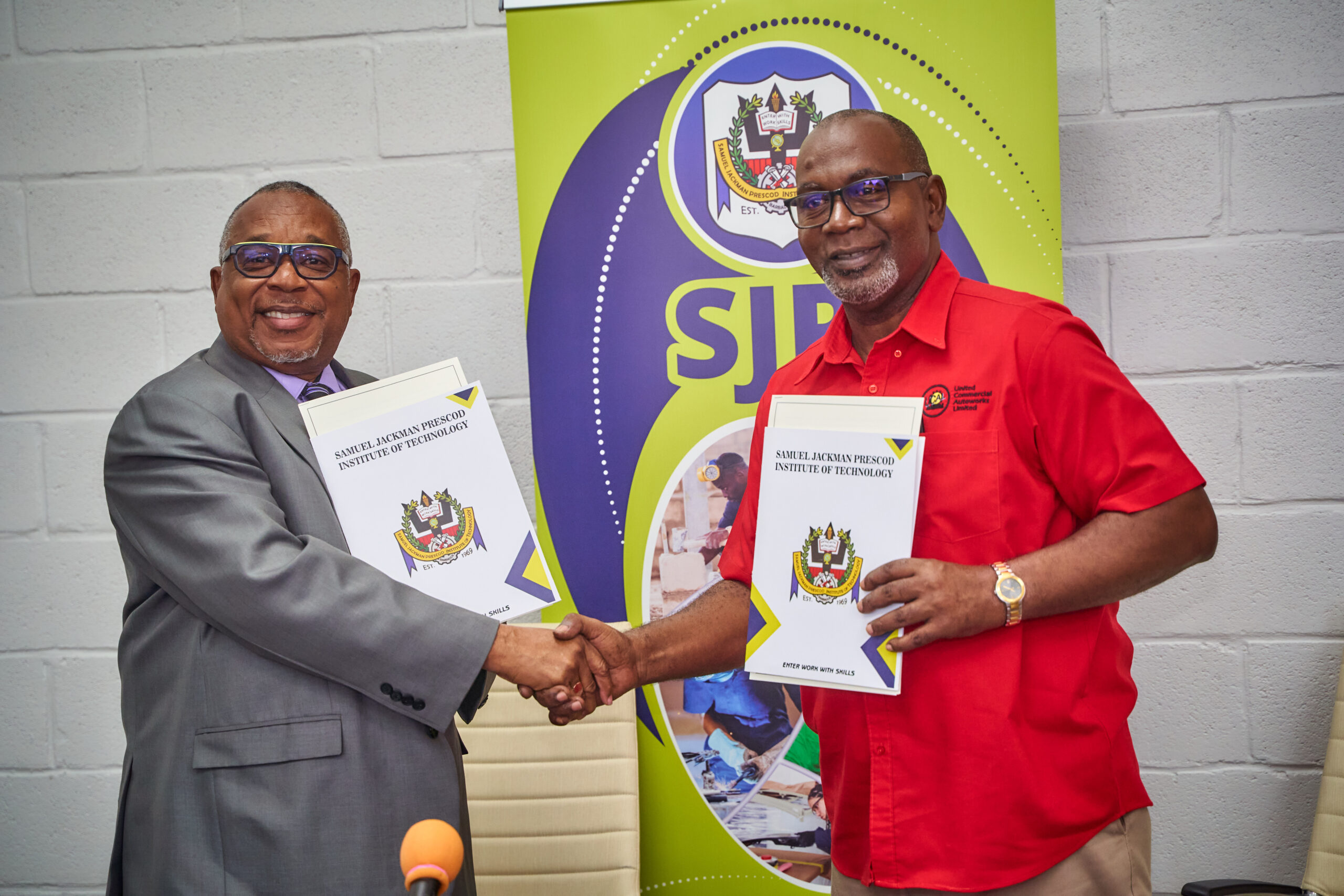 SJPI Principal Ian Drakes (left) and Managing Director of United Commercial Autoworks Limited Pedro Stanford shaking hands moments after signing the MOU.